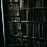 black wooden ladder beside brown wooden bookshelf